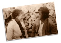 Sepia photo of two 1930s ladies smiling and chatting